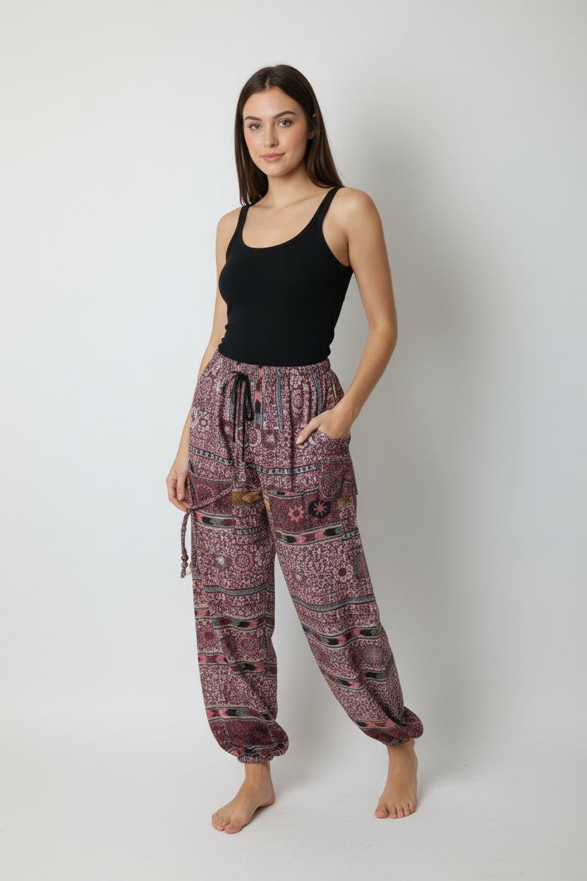 Patterned pants hanging on a wooden hanger against a white background