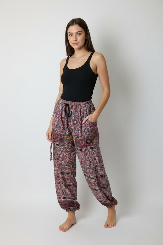 Patterned pants hanging on a wooden hanger against a white background