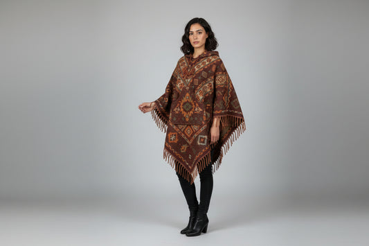 Woman wearing a patterned poncho on a gray background