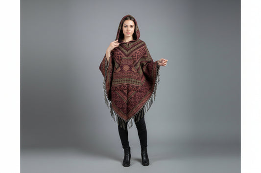 Woman wearing a patterned poncho against a gray background