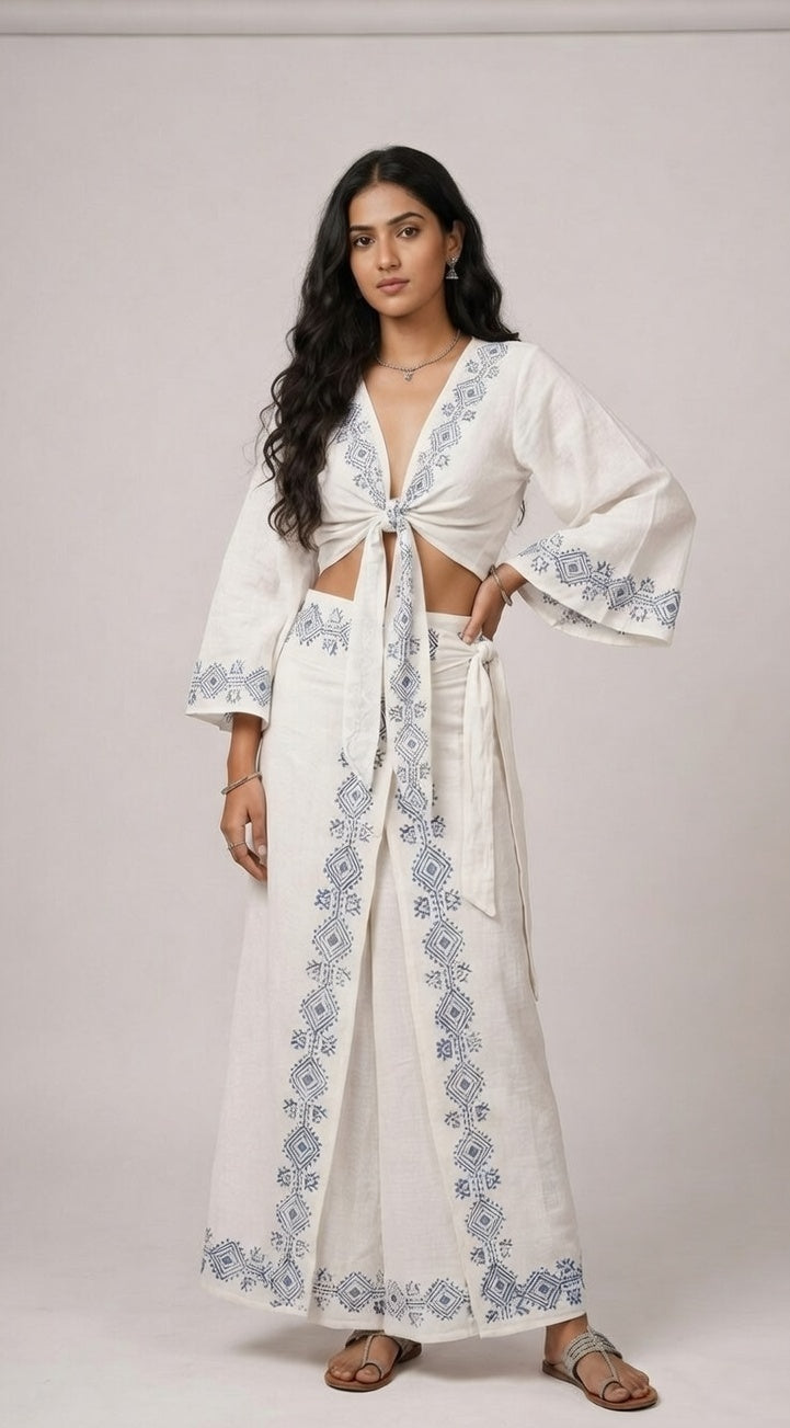 Woman wearing a white outfit with floral embroidery on a plain background